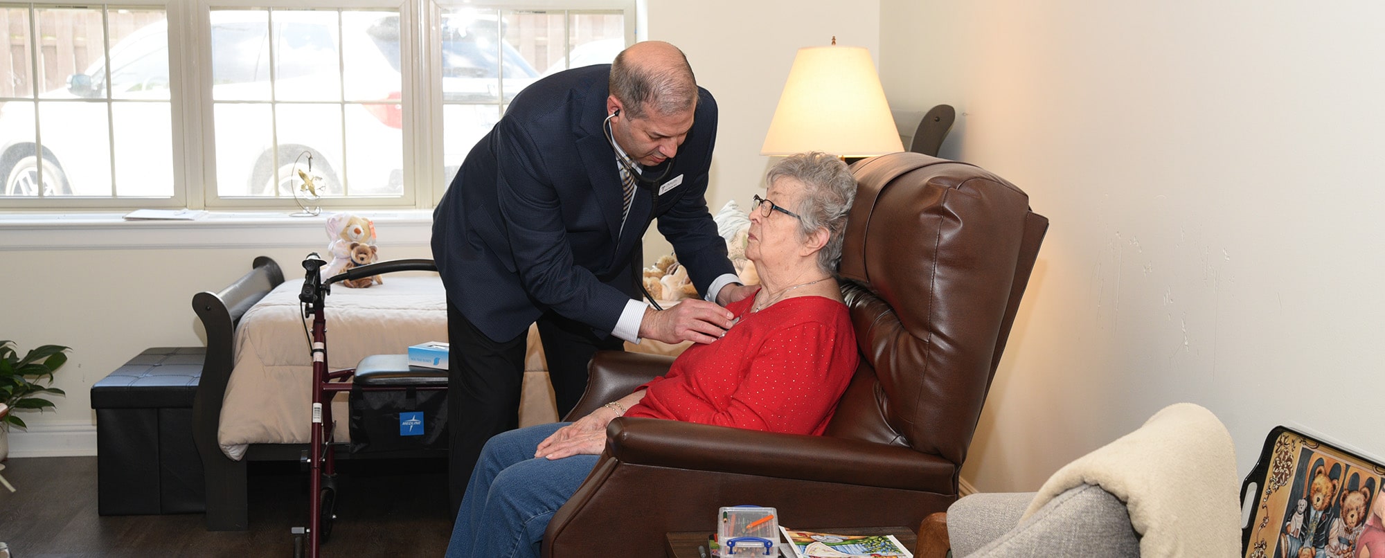 Dr. Sarafa taking an elderly patient's heartrate.